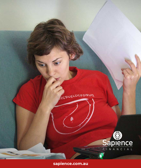 young person sitting on sofa looking at paperwork