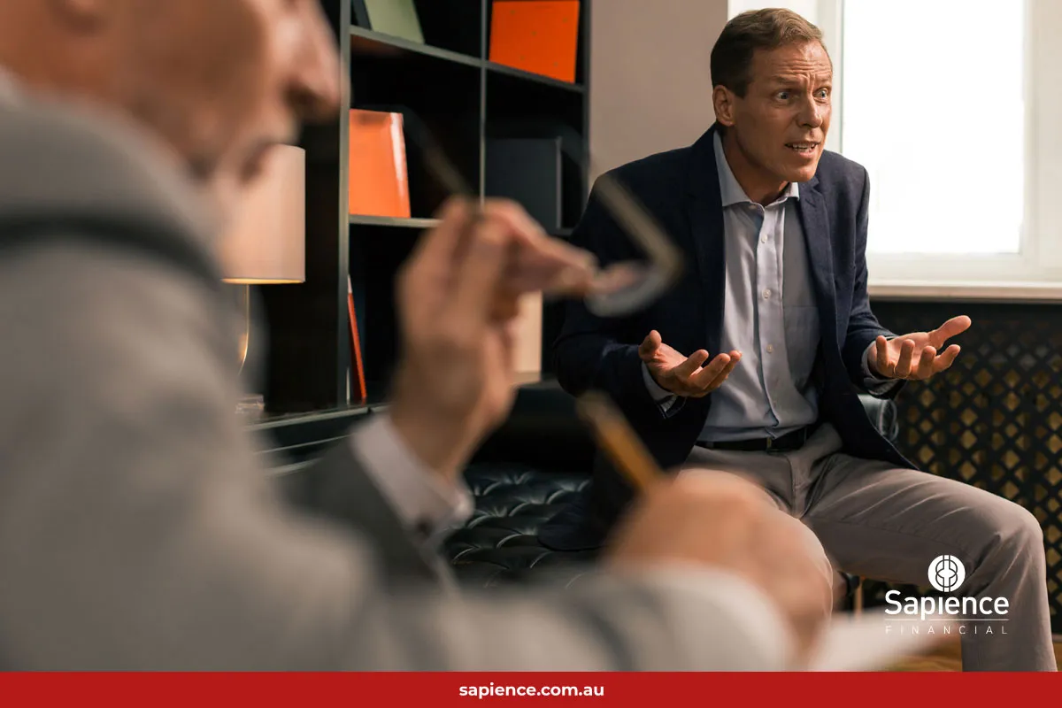 agitated male business owner sitting in a meeting receiving difficult news