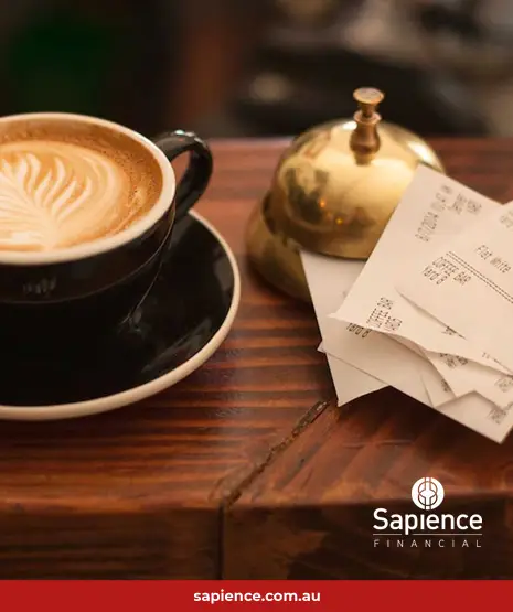 cup of coffee beside a stack of receipts