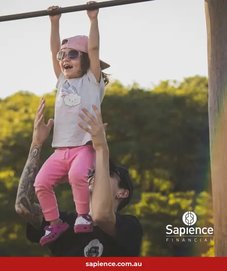 father and child playing on monkey bars