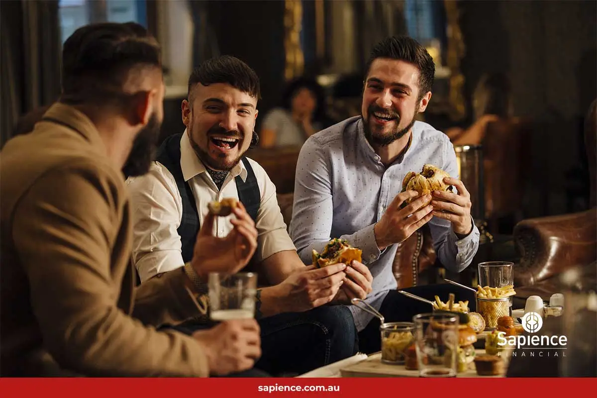 Three business friends eating a meal and laughing