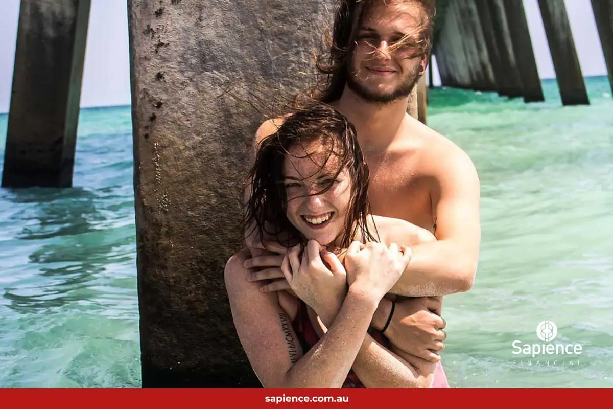 man hugging girl standing  in water
